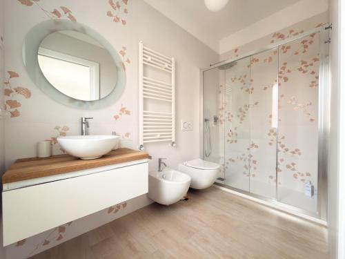 a bathroom with a sink and a toilet and a mirror at Riganvì Affittacamere Sestu in Sestu