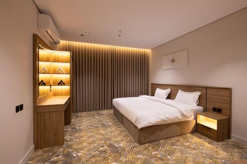 a bedroom with a large bed and a bathroom at فندق أجنحة رواق in Medina