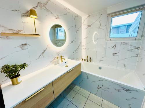 a bathroom with a white tub and a sink at L' Évéa Rooftop in Le Relecq-Kerhuon