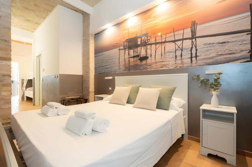 a bedroom with a large white bed with towels on it at Heart of Pescara Elegant Suites - Chic Suites in Pescara Center & 2 steps from Sea - AC & Wifi in Pescara