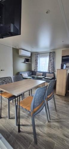 a room with tables and chairs in a room at Monpetitmobilhome in Ascarat