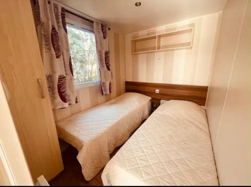 two beds in a small room with a window at Au Valras plage in Sérignan