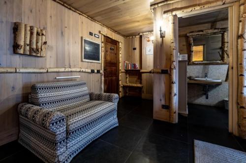 ein Wohnzimmer mit Sofa und Waschbecken in der Unterkunft Hotel Letterario Locanda Collomb in La Thuile