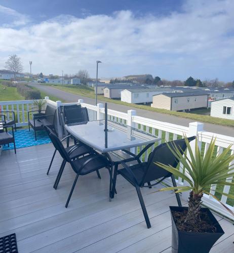 a wooden deck with a table and chairs on it at JSNHolidays at Craig Tara Holiday Park in Ayr