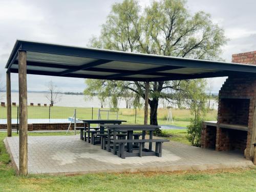 a picnic shelter with picnic tables in a park at Vaal Dam Getaway in Denysville