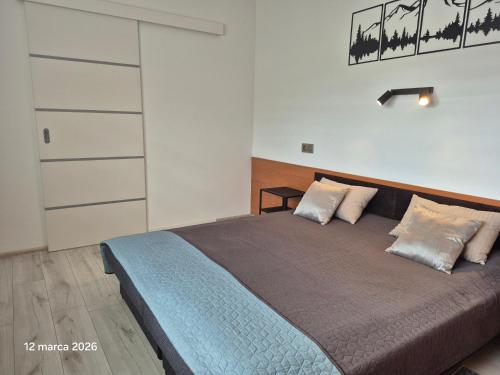 a bedroom with a large bed with two pillows at Apartament Bieszczady in Myczkowce