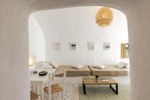 a white room with a bed and a table at Just Blue in Oia