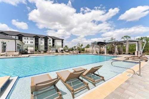 a large swimming pool with lounge chairs and condos at Landing Amazing 1BD Gym Clubhouse in Fort Myers