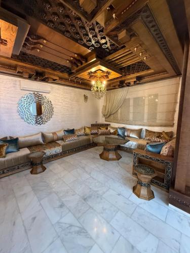 a large living room with couches and a chandelier at Exceptional Villa Pool in Oujda
