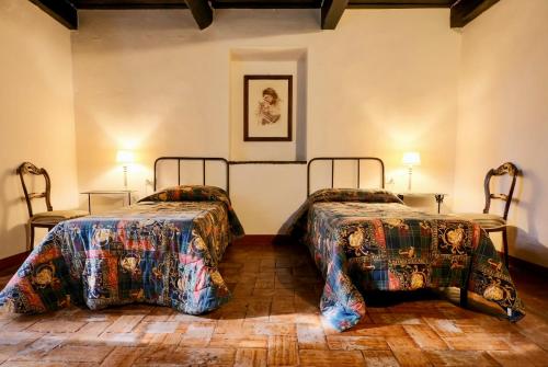 ein Schlafzimmer mit zwei Betten, zwei Tischen und zwei Lampen in der Unterkunft Frascole in Dicomano