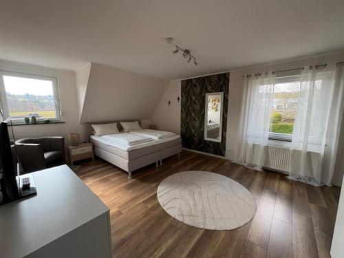 a bedroom with a bed and a couch and a table at Gästehaus Eifelzauber in Kelberg