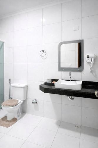 a bathroom with a toilet and a sink and a mirror at CS2 - Ampla - Suítes e Ar-Cond em Todos os Quartos in Juazeiro do Norte