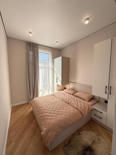 a bedroom with a large bed and a window at Коттедж Alfa in Koshkolʼ