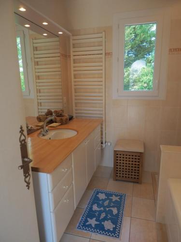 a bathroom with a sink and a mirror at Renovated villa by the ocean in Barbâtre