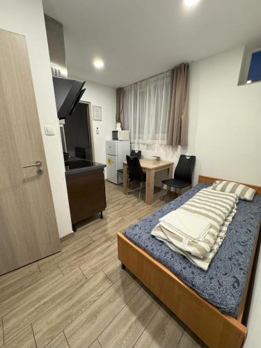a bedroom with a bed and a living room at Beregi Apartman in Tiszaújváros