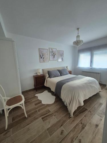 a bedroom with a large bed and a chair at Casa La Candela in Montemayor del Río