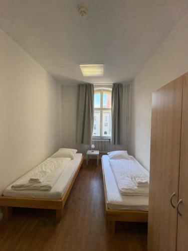 a room with two beds and a window at Haus St Vinzenz in Berlin