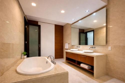 a bathroom with a tub and a large mirror at Straits Quay Seafront Suite l Panoramic Seaview in Tanjong Tokong