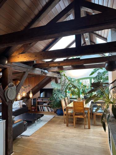 a dining room with a table and some plants at BLUELAND Loft in Hechendorf