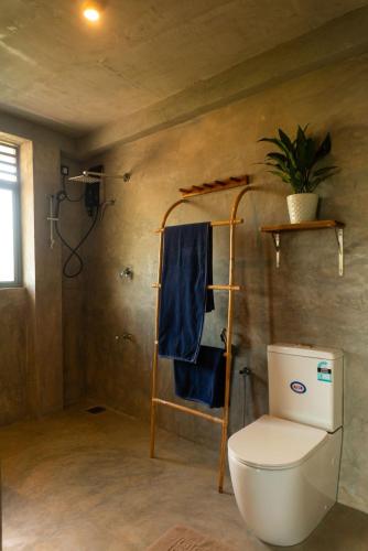 a bathroom with a toilet and a blue towel at BUKU BUKU by Bara Beach in Galle