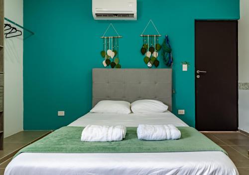 a bedroom with a bed with two pillows on it at X Mahaná Apartamentos Temáticos in Mérida