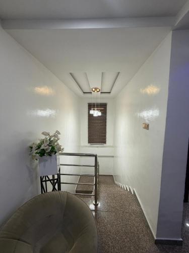 a hallway with white walls and a stair case at 3 Bedroom Flat Short Let in Iseri