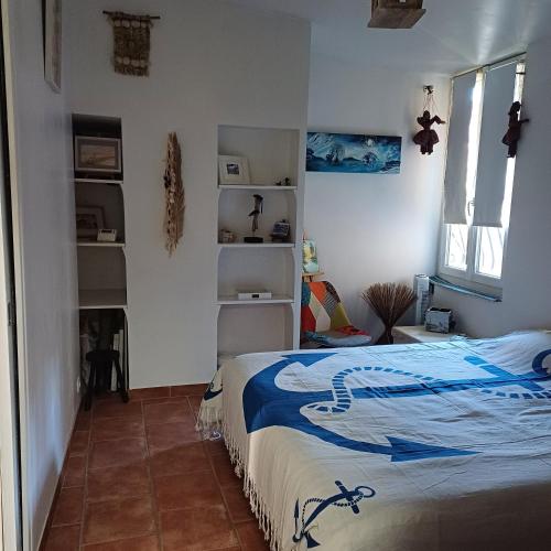 a bedroom with a bed with a blue and white bedspread at L'atelier d'LN in La Roque-dʼAnthéron