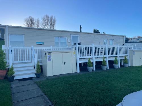 a house with a white fence and a yard at JSNHolidays at Craig Tara Holiday Park in Ayr