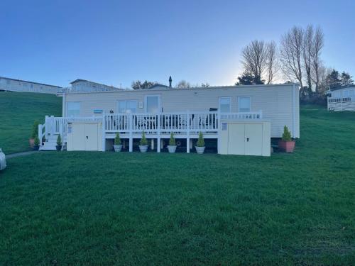 a large white house with a large yard at JSNHolidays at Craig Tara Holiday Park in Ayr