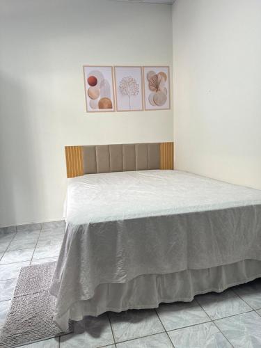 a bed in a room with a white wall at Apartamento Barbosa in Santarém