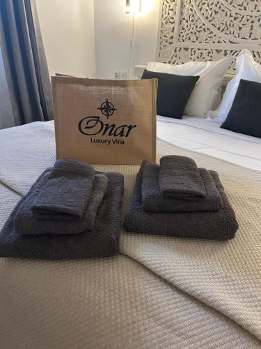 a sign on a bed with towels on it at Onar Luxury Villa - Adults Only in Lachania
