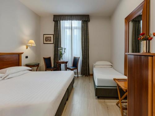 a hotel room with two beds and a table and chairs at Hotel Diplomatic in Rome