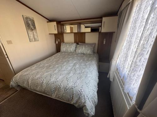 a bed in a small room in a caravan at Golden Anchor 6 Berth Caravan, Chapel St Leonards, 22 Wild Flower Meadow in Chapel Saint Leonards