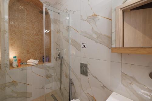 a bathroom with a shower with a glass door at Evmaria Luxury Cottage in Agios Myronas