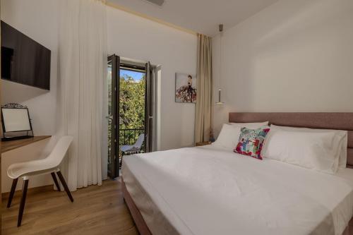 a bedroom with a large white bed and a desk at Evmaria Luxury Cottage in Agios Myronas