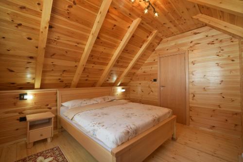 a bedroom with a bed in a wooden room at Planinski vuk chalet in Žabljak