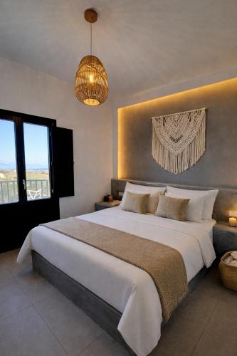 a bedroom with a large white bed and a chandelier at Atlantis Four in Éxo Goniá