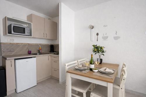 a kitchen with a table with chairs and a microwave at centre port le cocon 4 couchages in Cap d'Agde