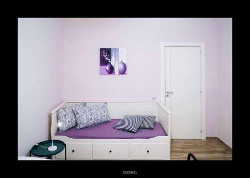 a bed with purple sheets and pillows in a room at Casa Porta D'Amalfi vicino Stazione e terminal Sita Salerno in Salerno