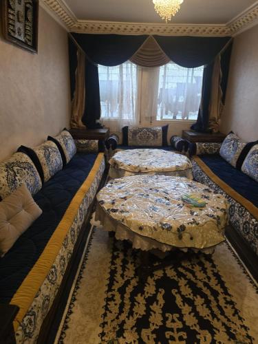 a living room with two beds and a window at Residence Bassatine in Temara