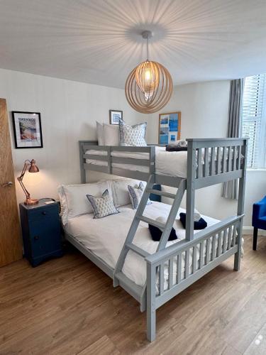 a bedroom with two bunk beds and a chandelier at Purbeck Hill View in Swanage
