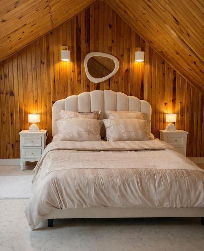a bedroom with a large white bed with wooden walls at Maison 8p 4ch A31 Recharge electrique in Rolampont