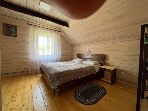 a bedroom with a bed in a log cabin at Наш котедж in Krivopolʼye