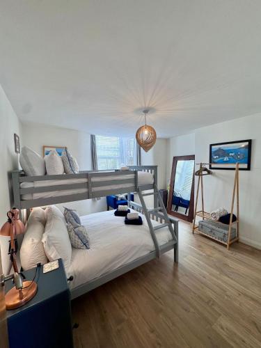 a bedroom with two bunk beds and a desk at Purbeck Hill View in Swanage