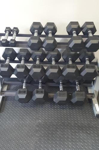 a pile of dumbbells on a rack in a gym at Hotel Piccadilly in Fresno