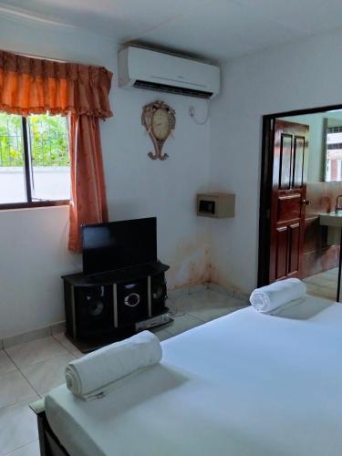 a room with two beds and a television in it at New Villa Senor Beruwala in Beruwala
