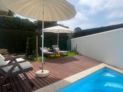 a patio with an umbrella and a swimming pool at Signature Guesthouse in Porto