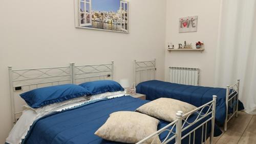 a bedroom with two beds with blue pillows at Alba Ionica Taranto in Taranto