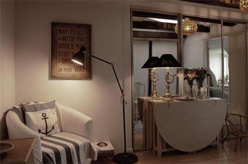 a living room with a lamp and a chair and a table at Cozy loft living in Malmö