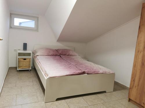 a bedroom with a bed with a pink blanket at apartma Jelka in Novigrad Istria